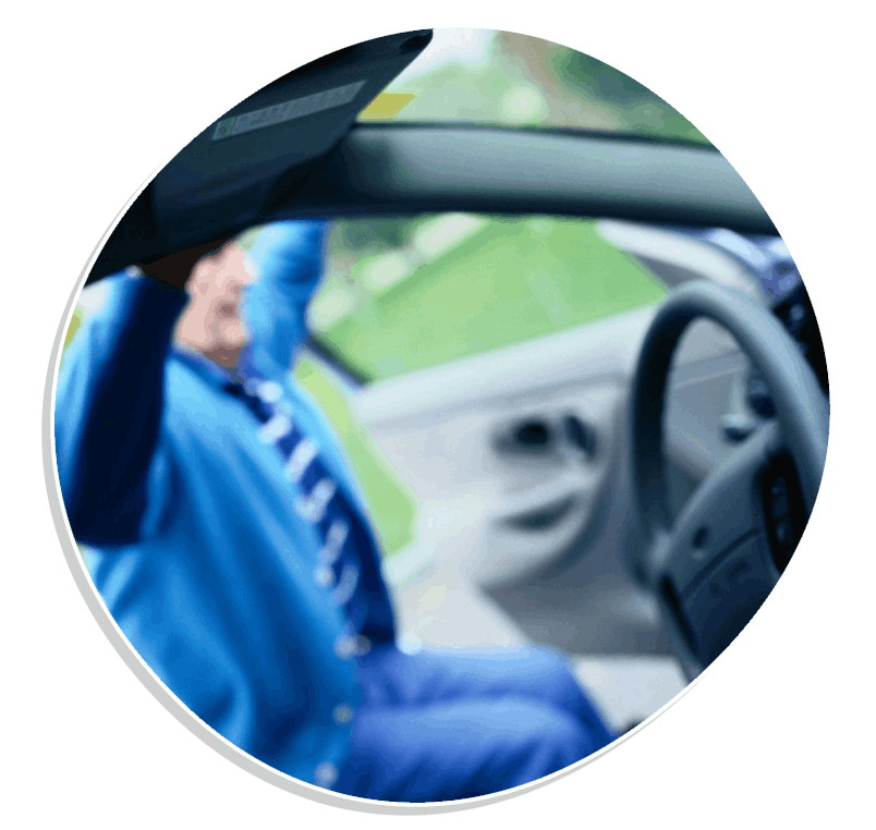 Car driver wearing blue medical gloves with hands on steering wheel